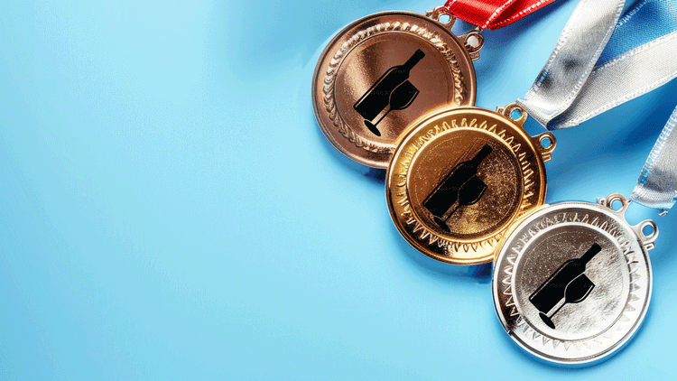 gold, silver and bronze medal with wine bottles on them representing wine consumption by country